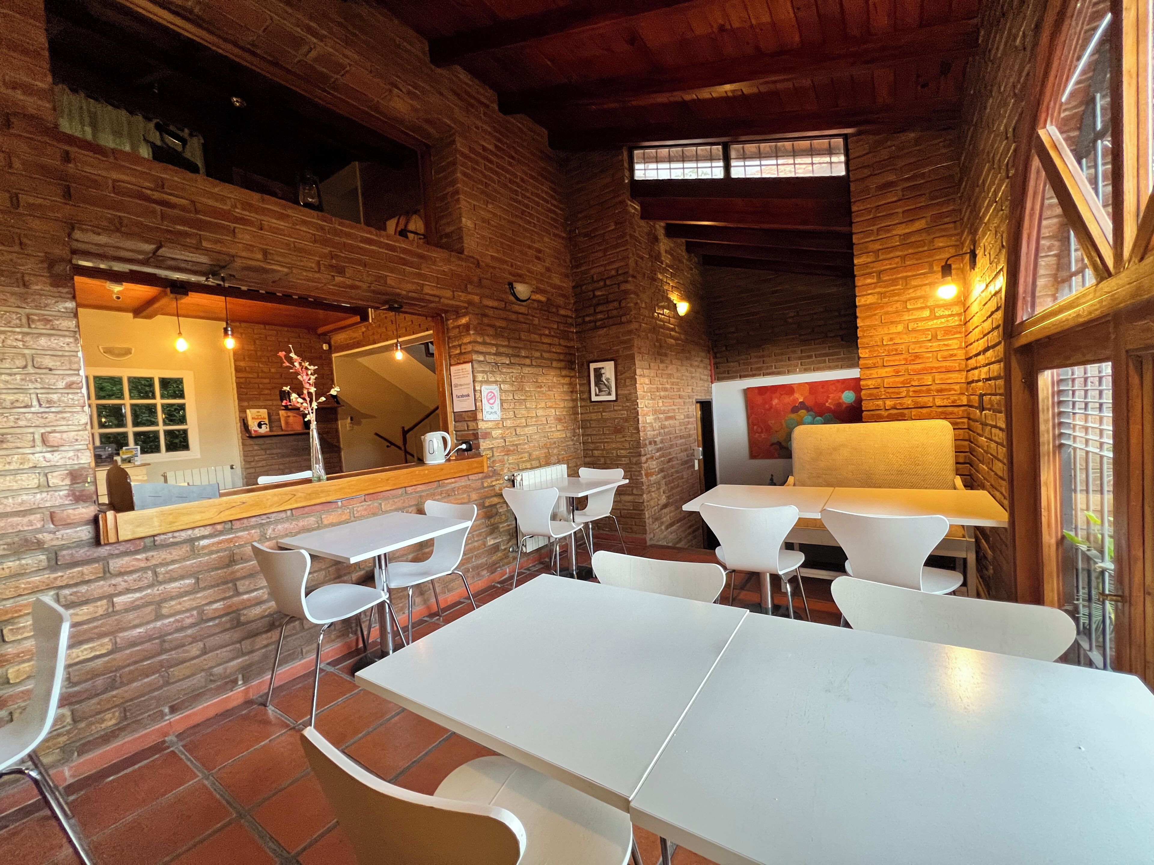 A restaurant with brick walls, white tables, and chairs.