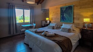 Un dormitorio con una cama grande, un escritorio y una ventana con cortinas.