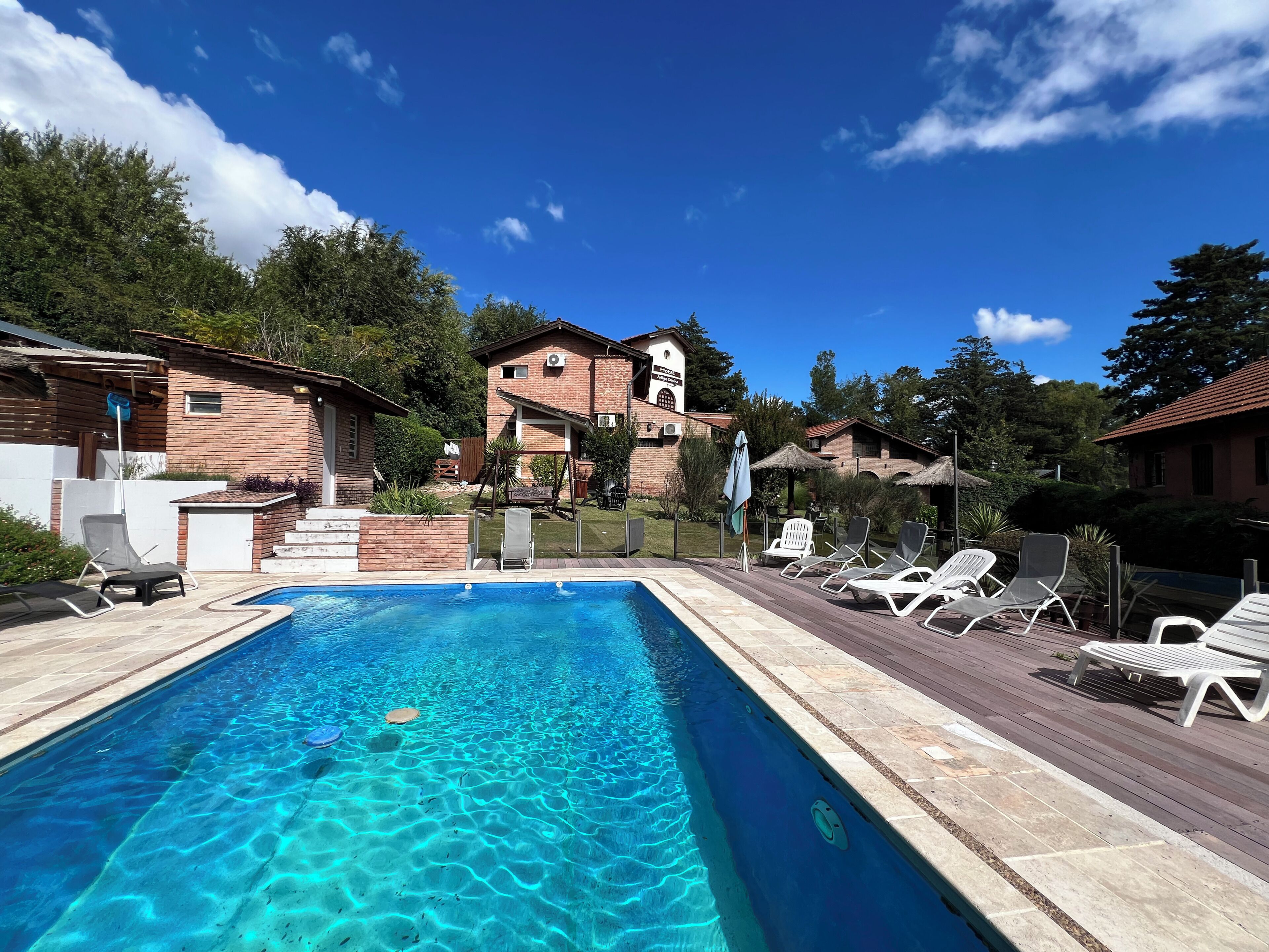 Una piscina al aire libre, sombrillas, tumbonas
