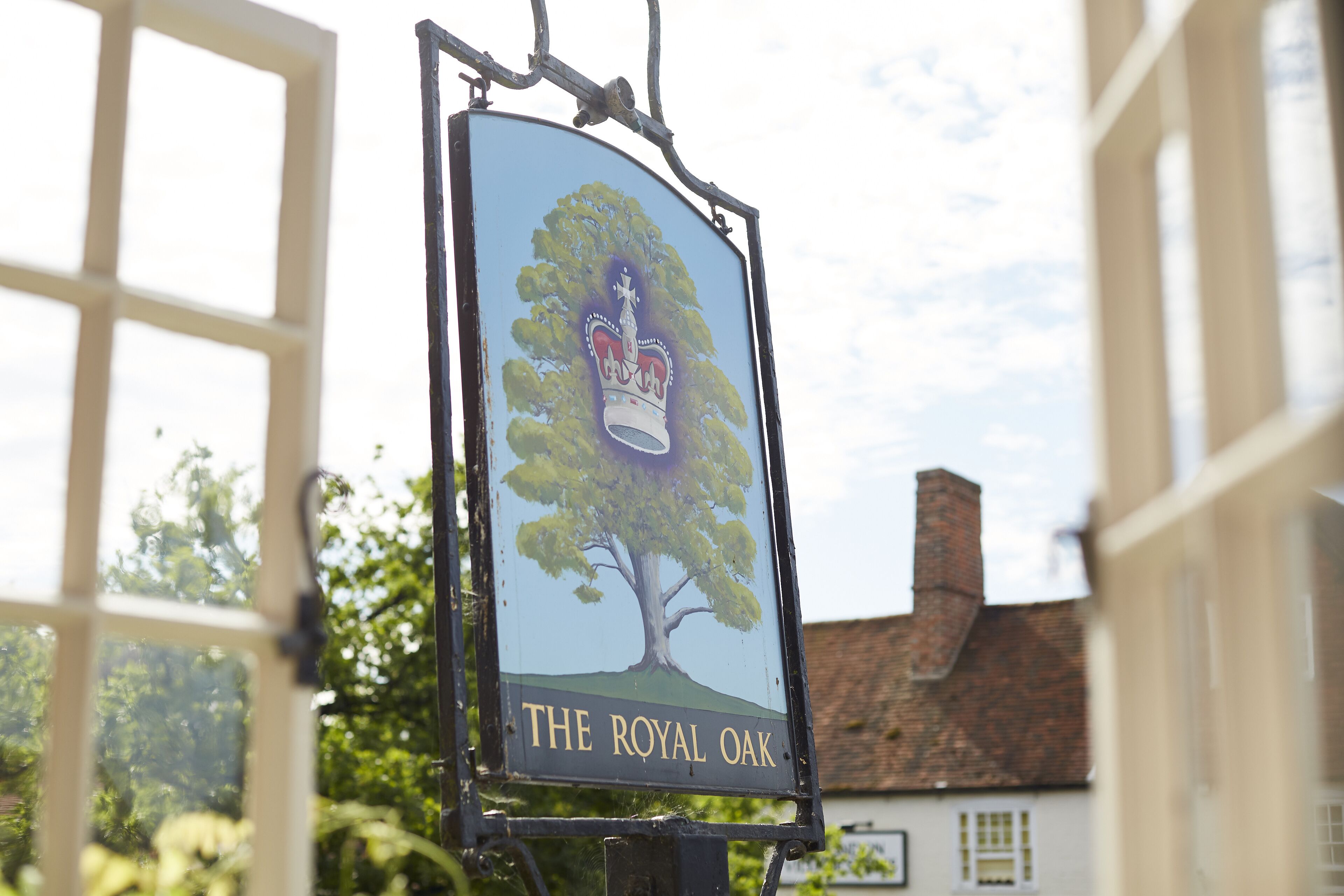 Une enseigne de pub représentant un arbre et une couronne, intitulée « The Royal Oak ».