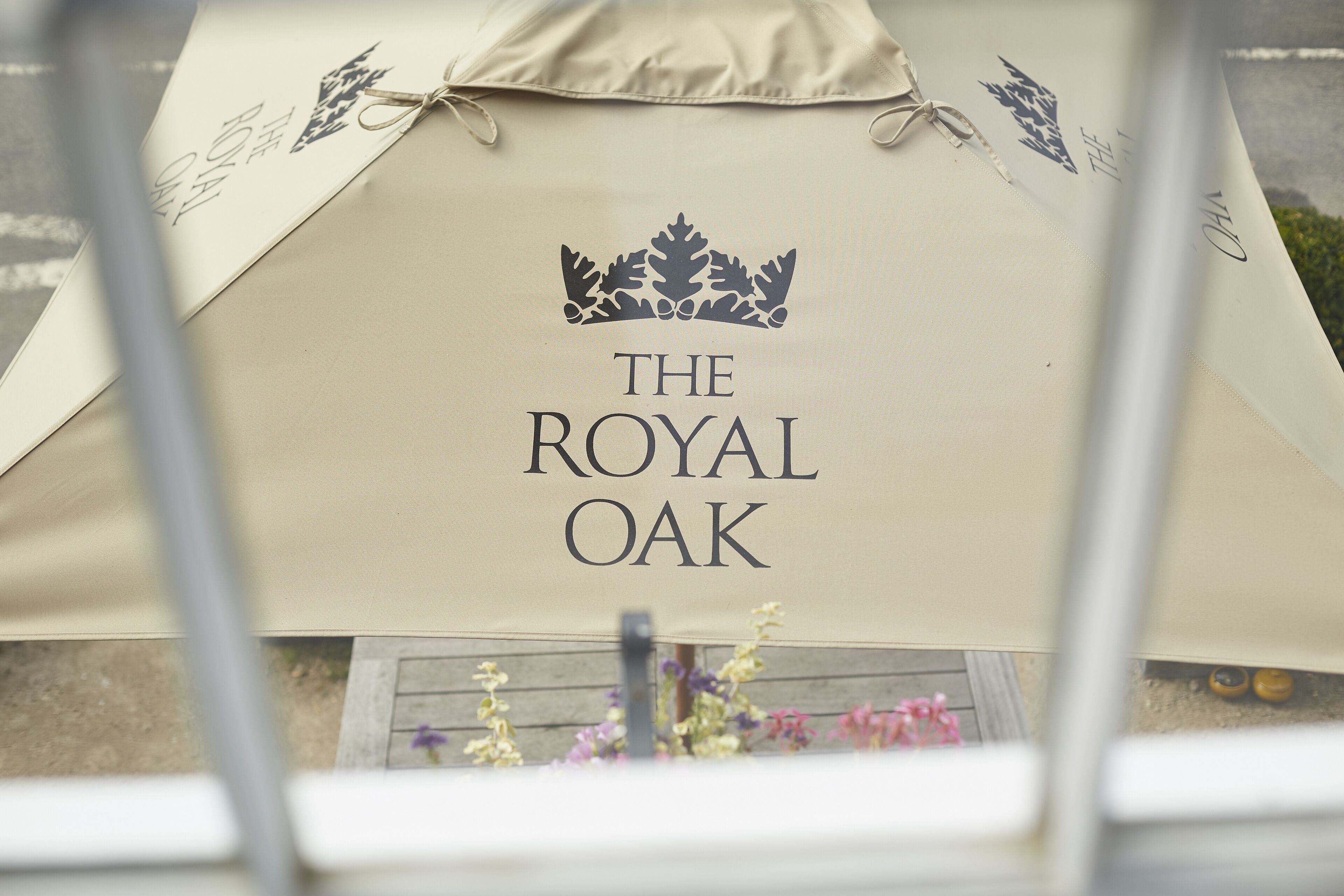 Tecido bege com a inscrição "THE ROYAL OAK" e um logotipo de coroa.