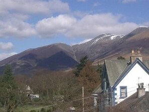 A rural landscape with a house and a mountain in the background. - The Silverdale (Keswick)