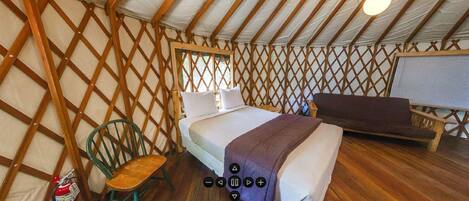 Um quarto com uma cama, uma cadeira e um sofá.