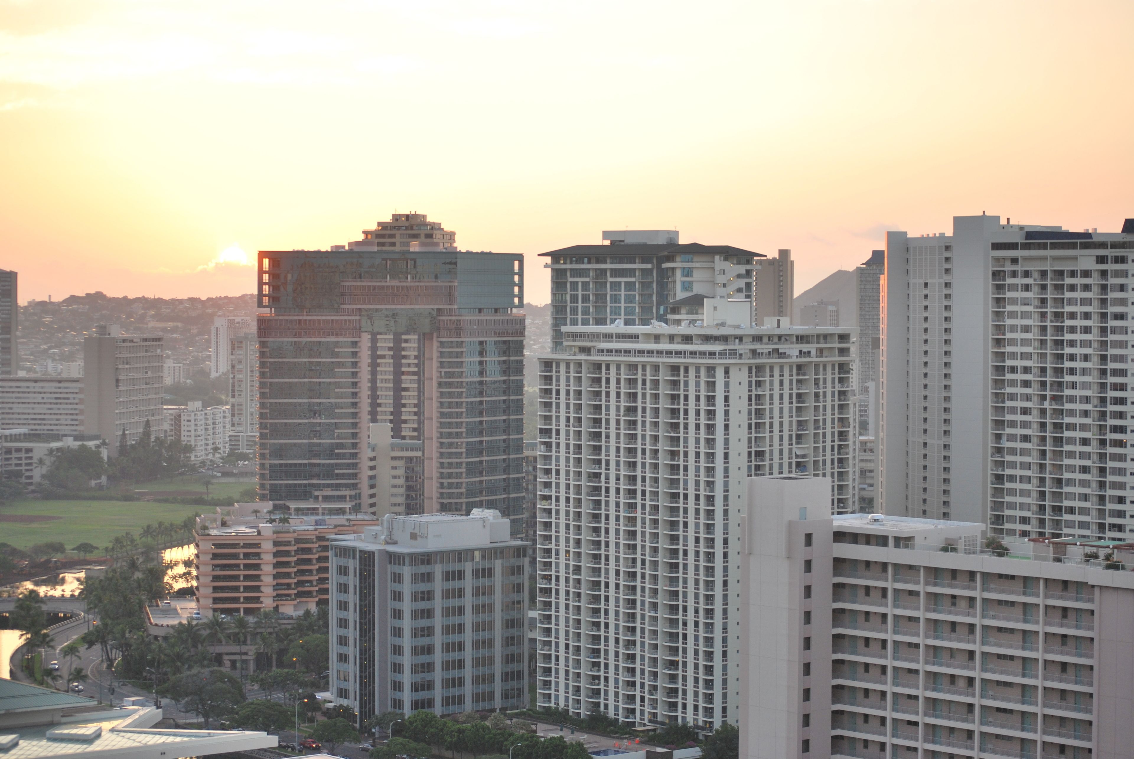 A high-rise building with a modern architectural design, featuring a grid-like facade and multiple balconies.