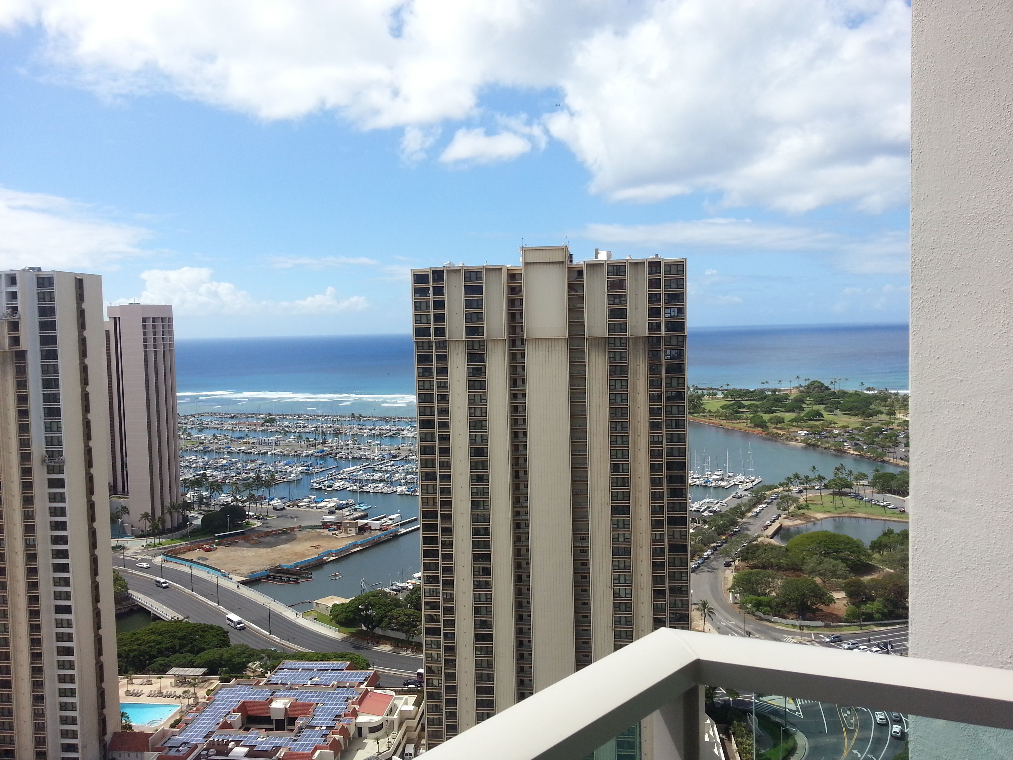 A high-rise building with a marina and ocean view.