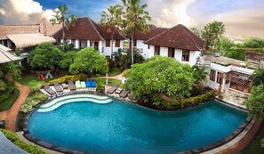 A resort with a swimming pool, lounge chairs, and tropical landscaping. - Ecosfera Hotel (Canggu)