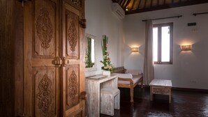 A wooden room with a large cabinet, a bench, and a small table. - Ecosfera Hotel (Canggu)