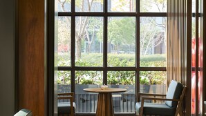 A modern interior with a large arched window, a round wooden table, and two chairs.