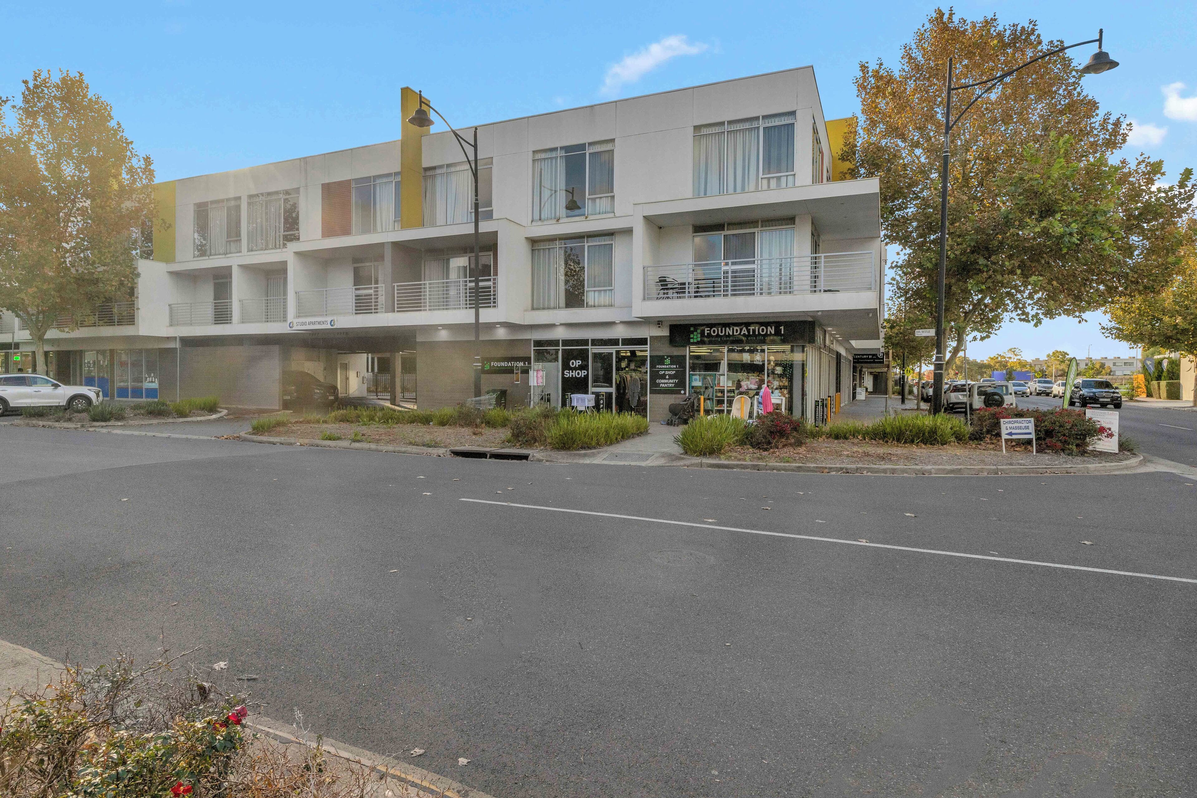 Un edificio de varios pisos con escaparate que dice 'Foundation 1' y una entrada visible.