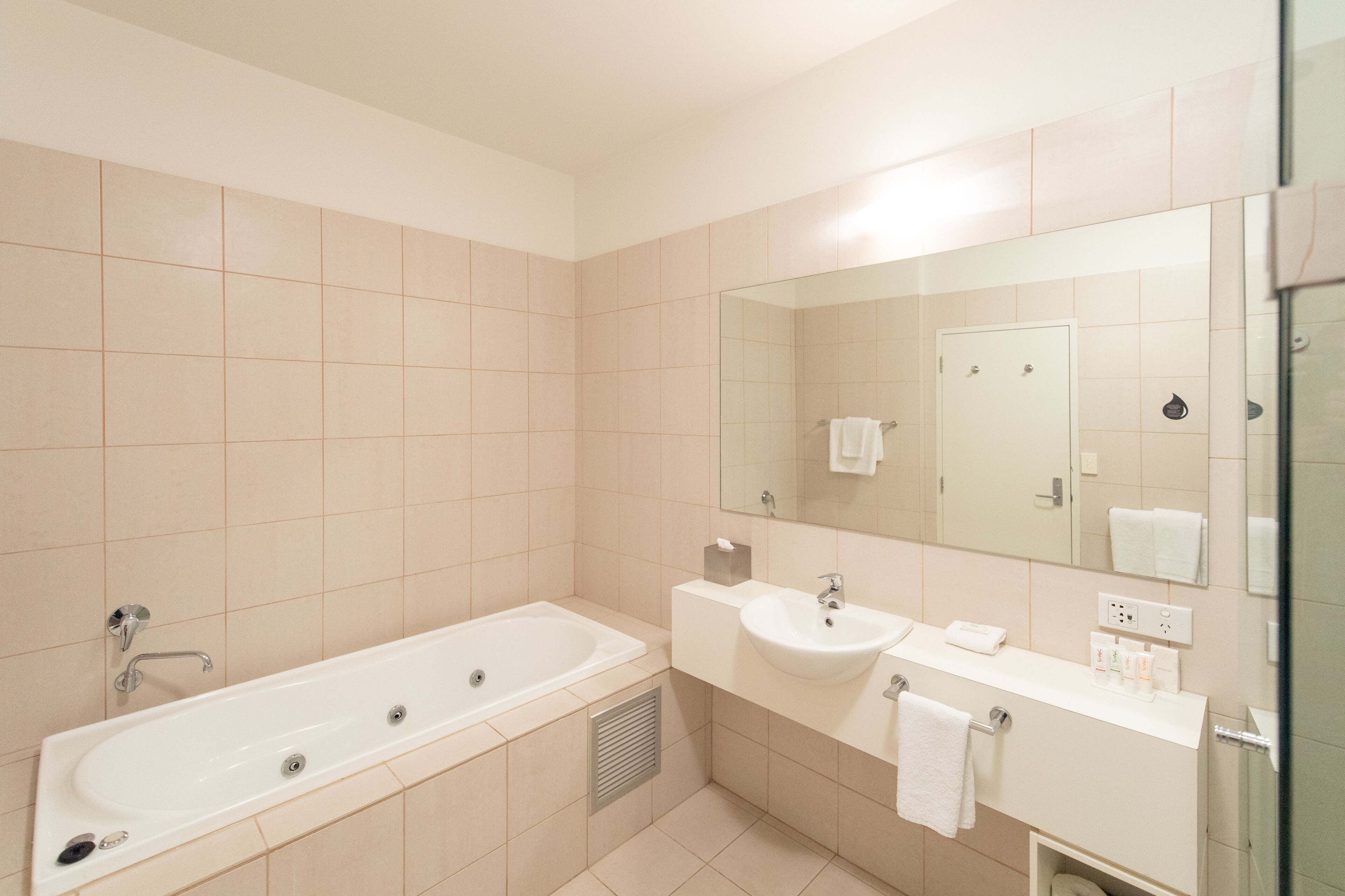 Un baño moderno con bañera, lavabo y espejo.