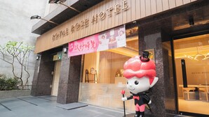 Exterior do Hotel Royal Rose com uma grande estátua de mascote em frente.
