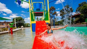 A water play area with a red slide and a water fountain. - Discovery Parks - Dubbo (Dubbo)