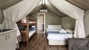 A tented room with bunk beds, a single bed, a small kitchenette, and a chair. - Discovery Parks - Dubbo (Dubbo)