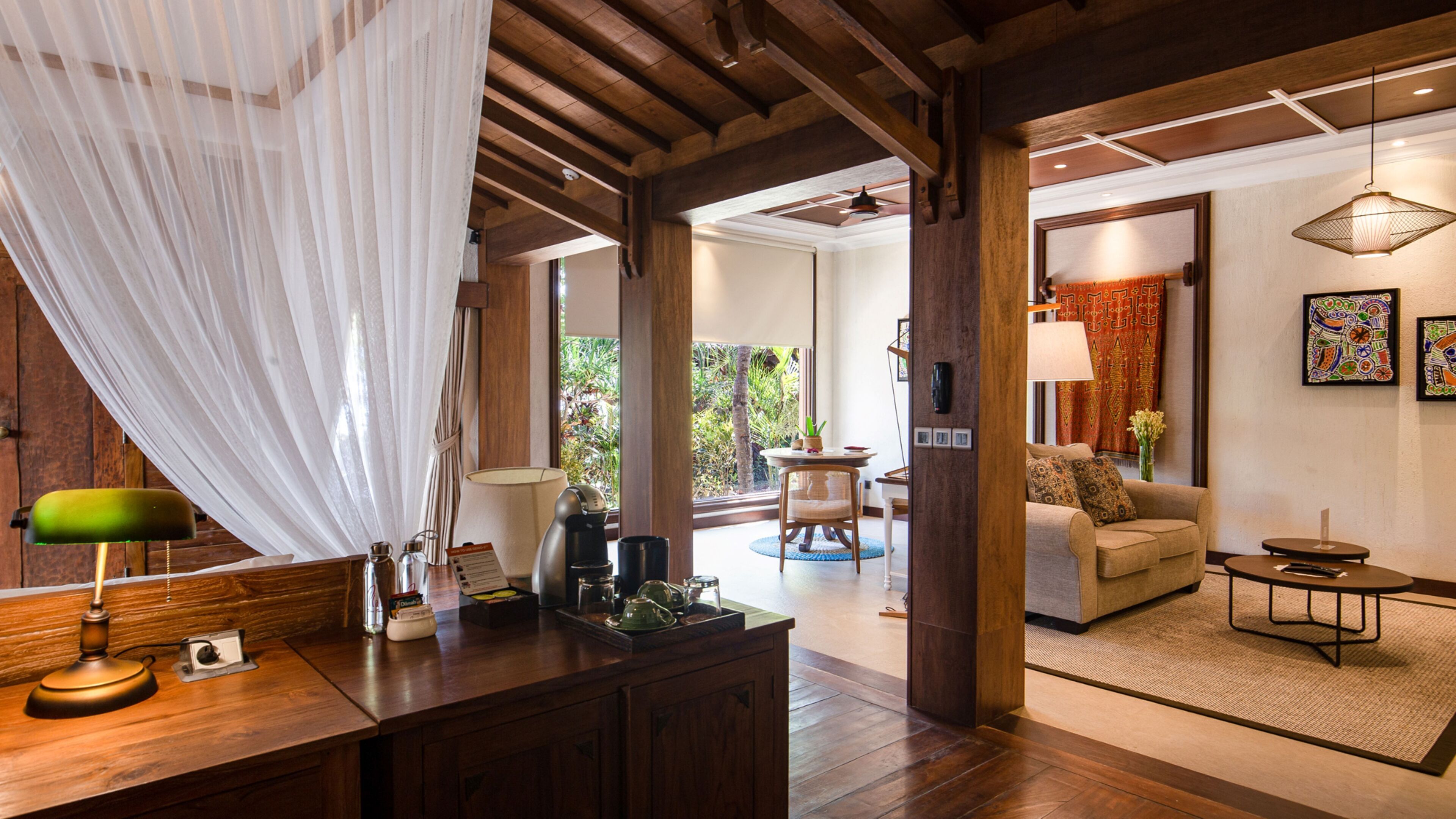 A spacious room with a wooden ceiling, a dining area with a table and chairs, and a living area with a sofa and a coffee table.