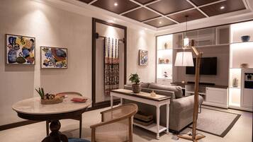 A modern living room with a sofa, coffee table, and a television. There are decorative items on the walls and a plant on the coffee table.