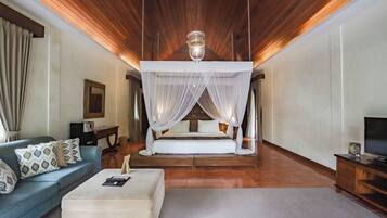 A bedroom with a canopy bed, a sofa, a television, and a wooden ceiling.