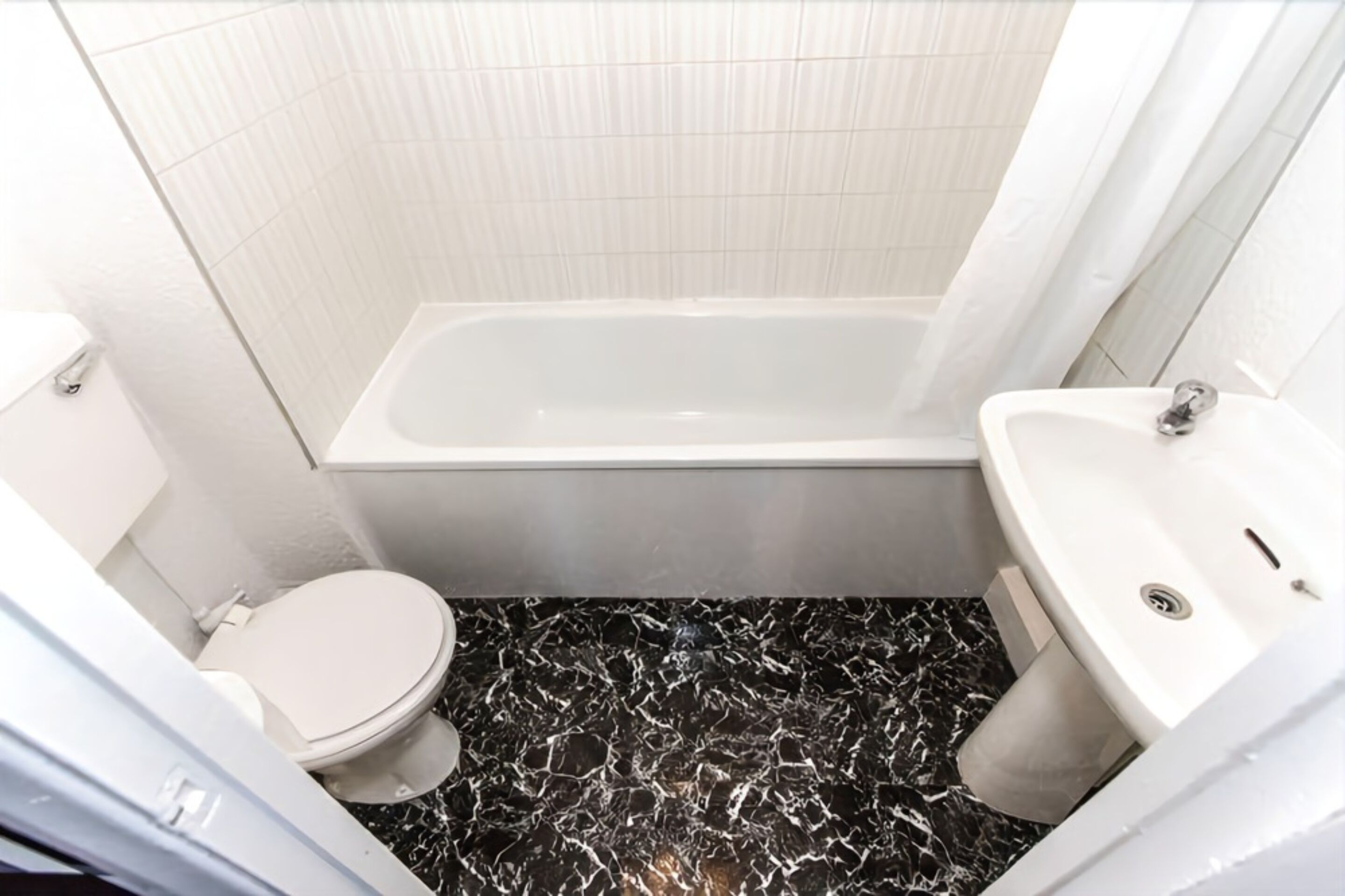 A bathroom with a toilet, a bathtub, and a sink.