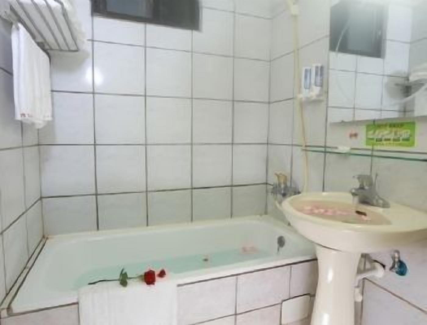 Un baño con bañera, lavabo y espejo.