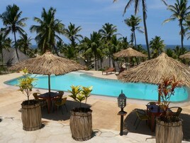 Una piscina al aire libre, camas de piscina gratis, sombrillas