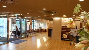 Un vestíbulo amplio con suelo de madera, mostrador de recepción y zona de estar.