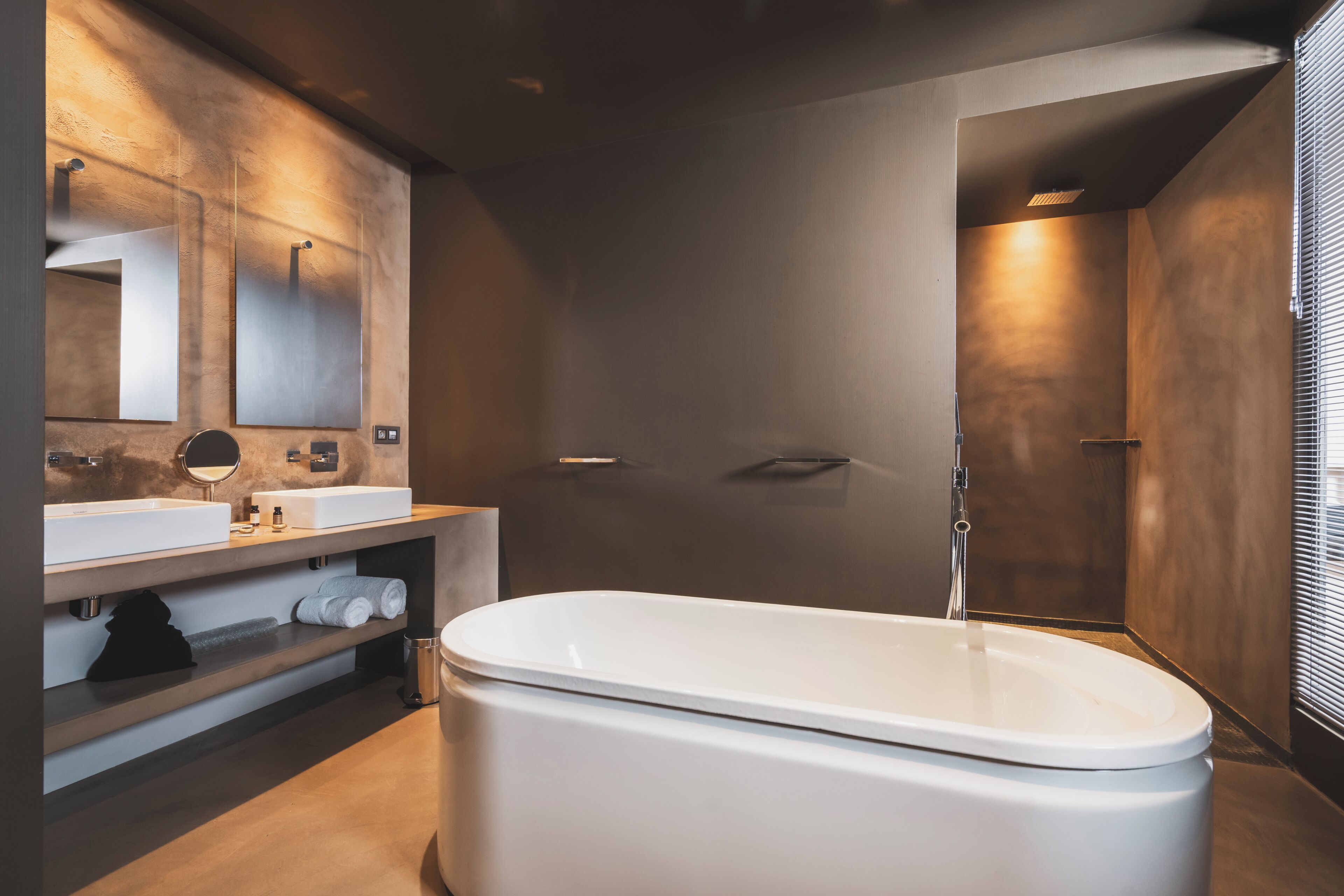 A modern bathroom with a freestanding bathtub, a vanity with a mirror, and a shower area.