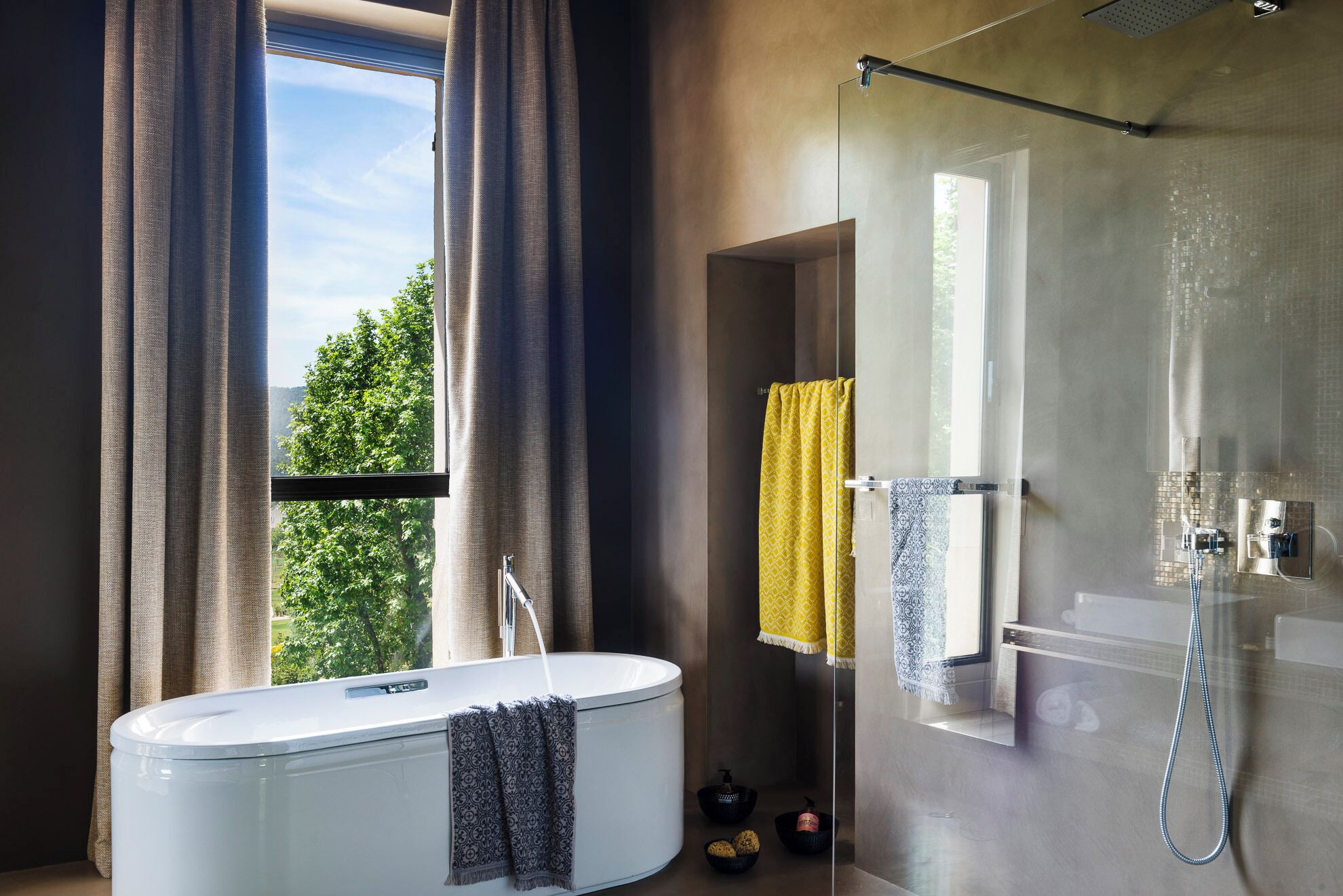 Un baño moderno con bañera, ducha y ventana grande.