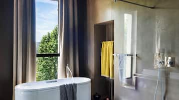 Un baño moderno con bañera, ducha y ventana grande.