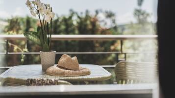 A round table with a woven hat and a potted orchid.