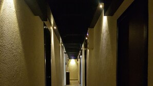 Un pasillo largo y estrecho con suelo de baldosas y paredes a ambos lados.