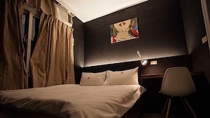 Un dormitorio con cama, escritorio y silla.