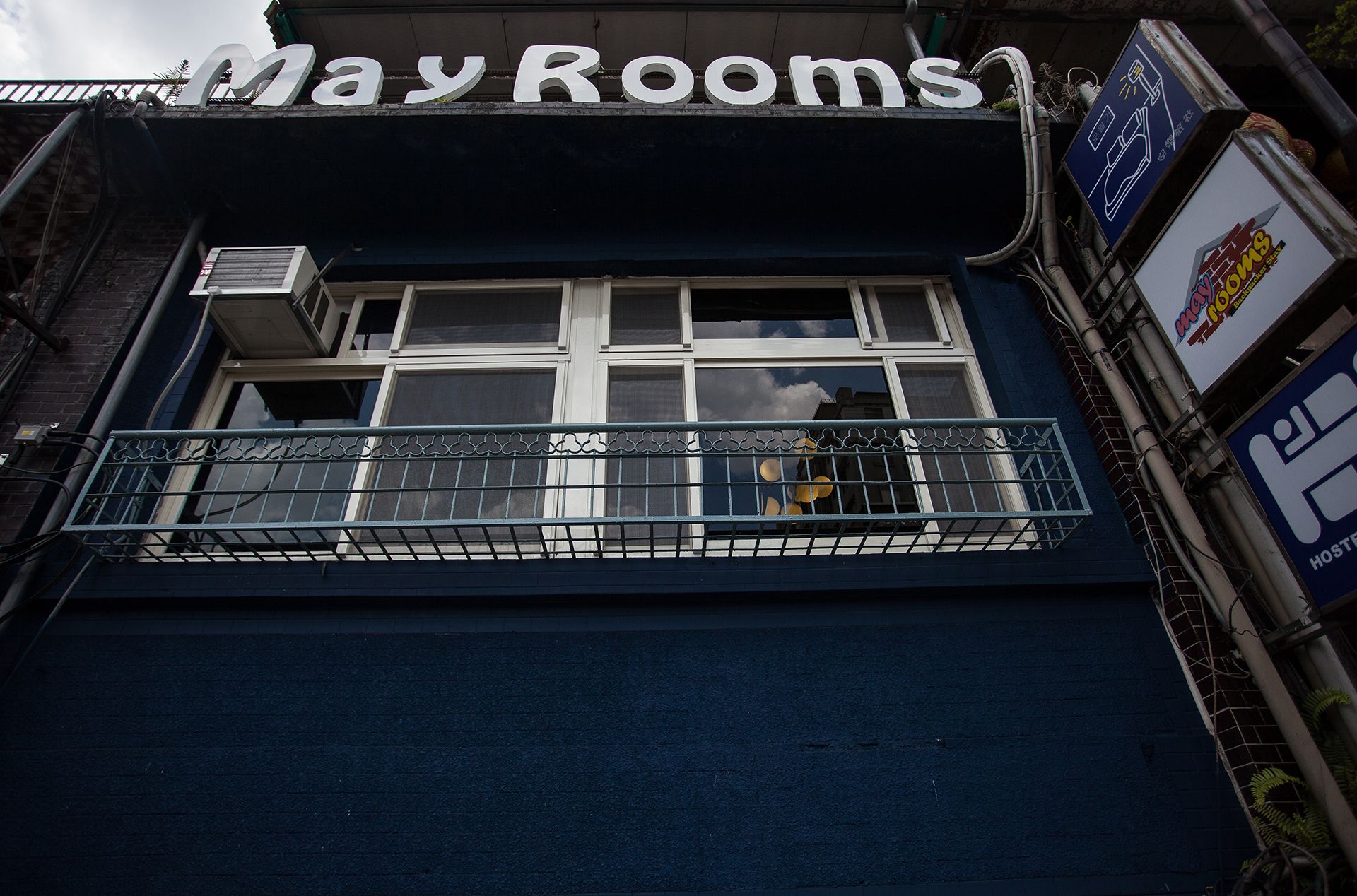 Un edificio con un letrero que dice "May Rooms" sobre la entrada.