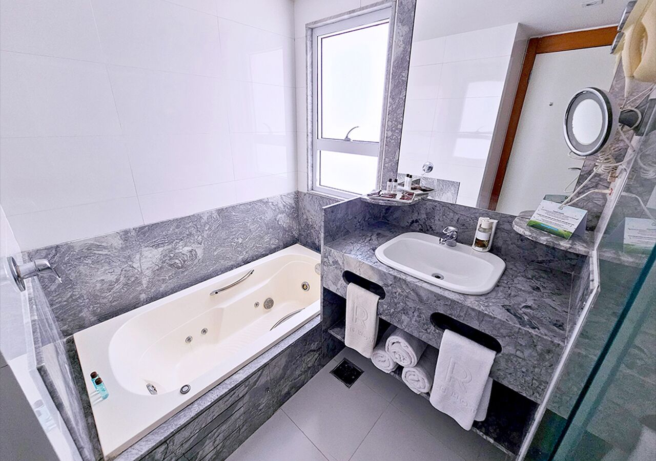 A modern bathroom with a bathtub, a sink, and a vanity.
