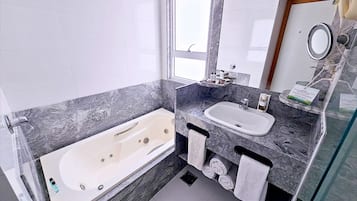 A modern bathroom with a bathtub, a sink, and a vanity.