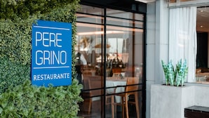 A restaurant sign with the name "PERE GRINO" and a view of the interior dining area.