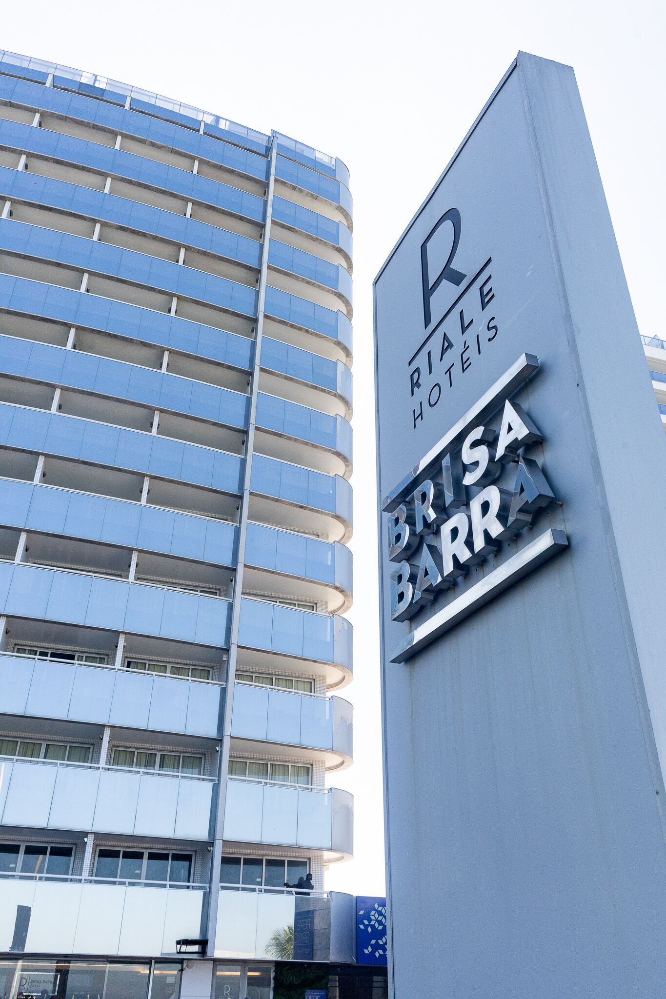 Placa de hotel com 'Rial Hotels' e 'Brisa Barr' em um edifício moderno.