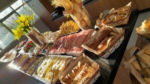 Un bufé con diversas opciones de comida, incluyendo carnes, quesos y panes.