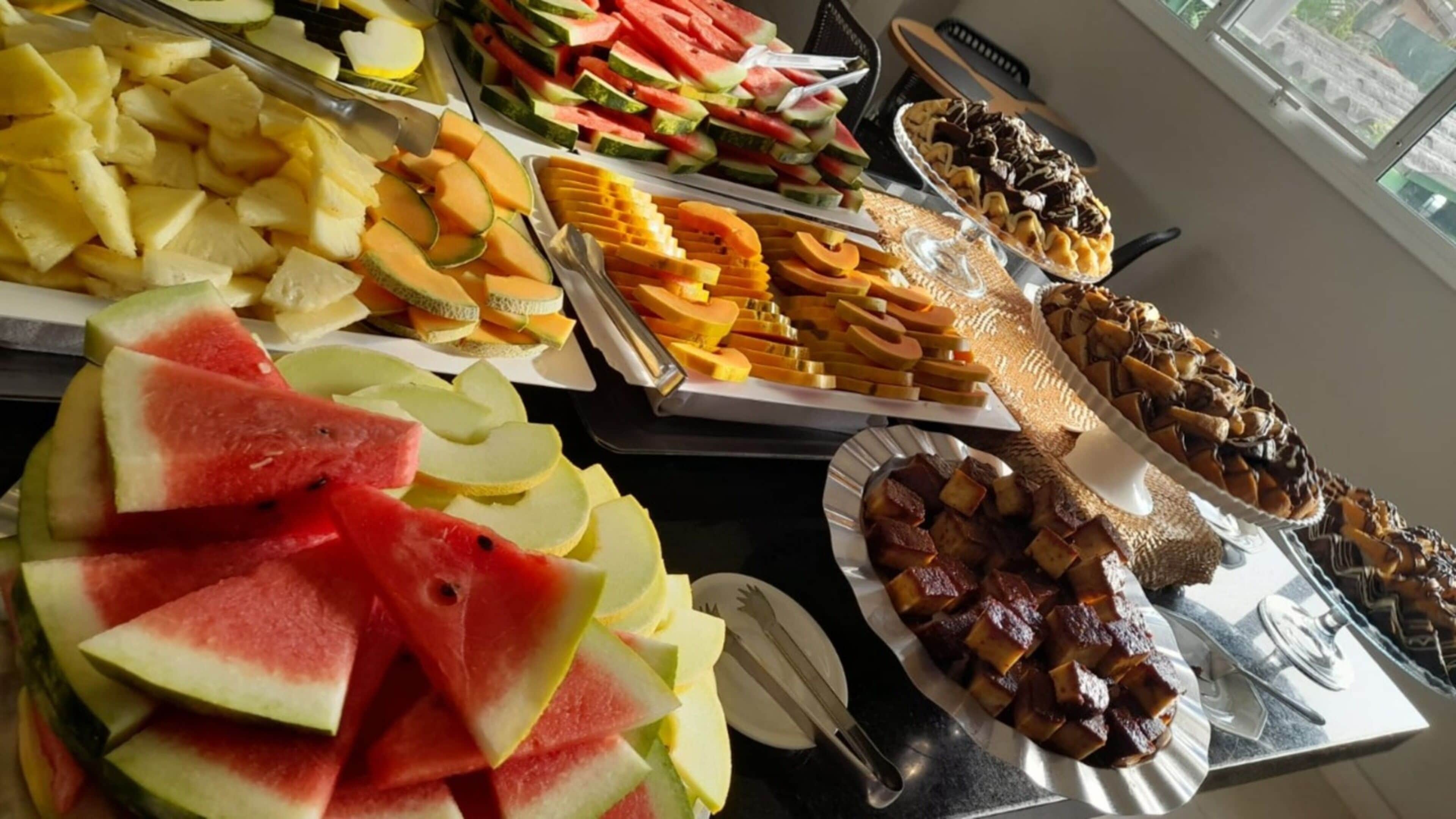 A buffet with various fruits and desserts.