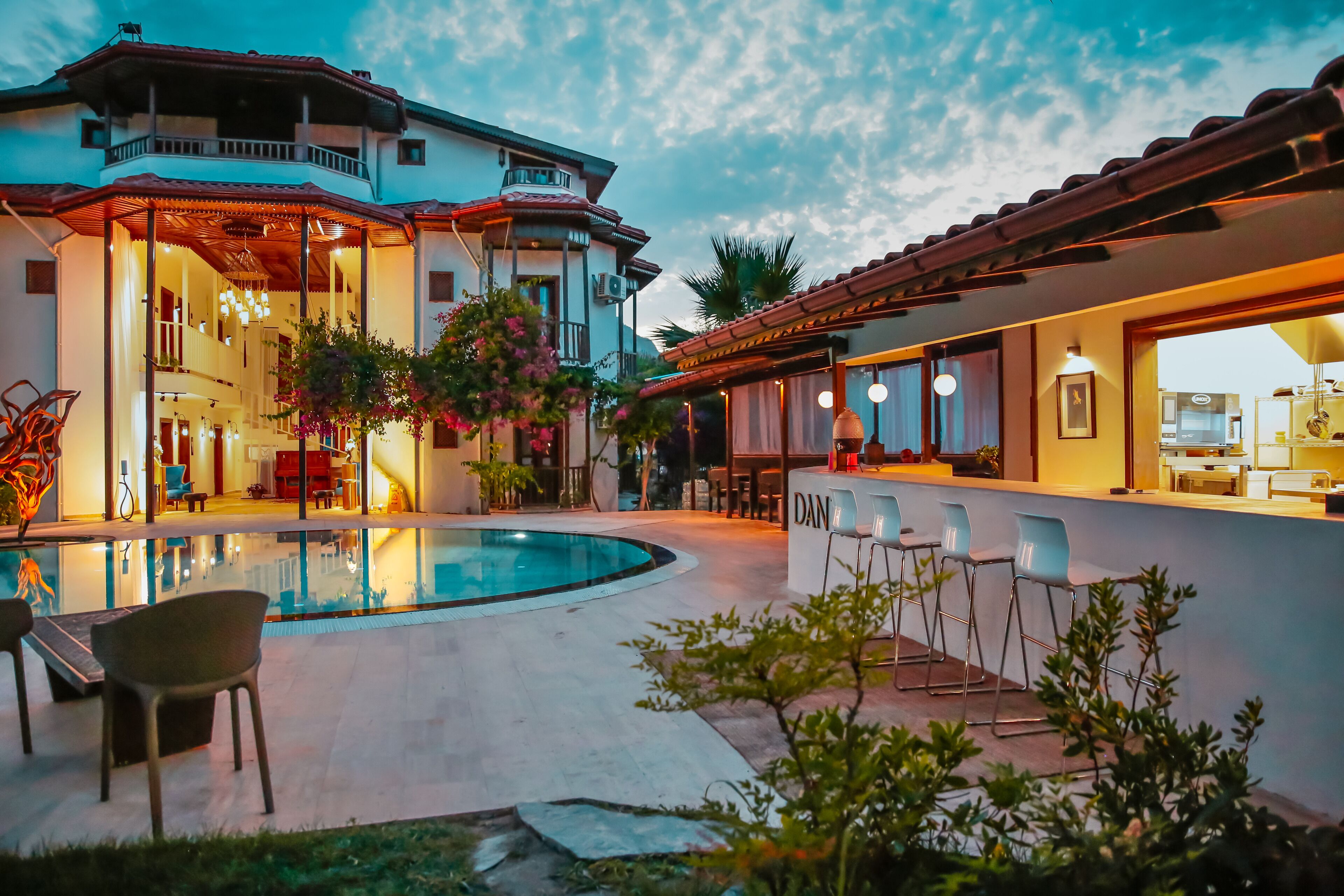 A modern house with a swimming pool, bar area, and outdoor seating.