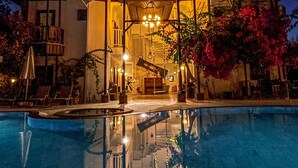 A hotel with a swimming pool, outdoor seating, and a well-lit entrance. - Murat Paşa Konağı Boutique Hotel (Ortaca)