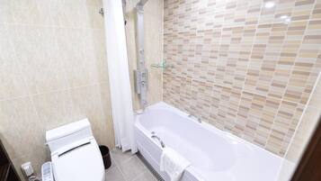 A bathroom with a toilet, a shower, and a bathtub.