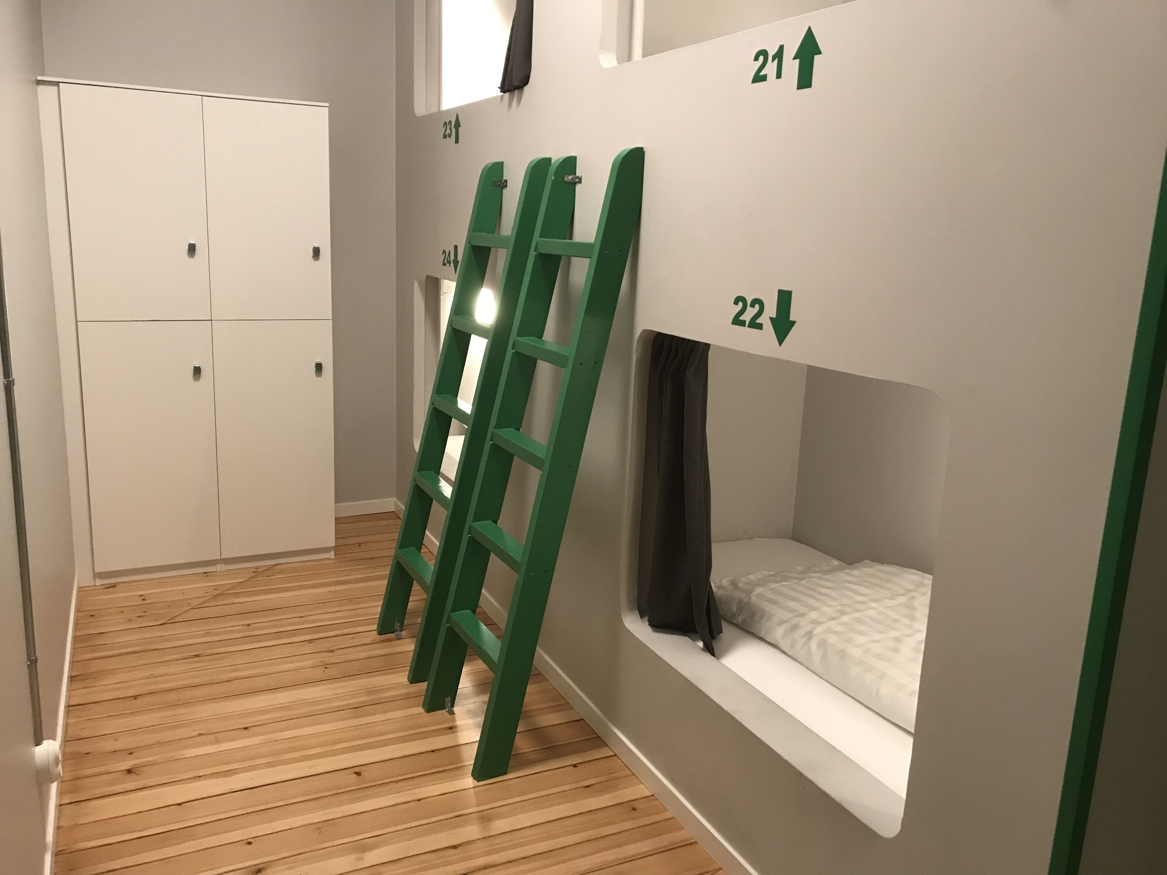Una habitación con literas, una escalera y un armario.