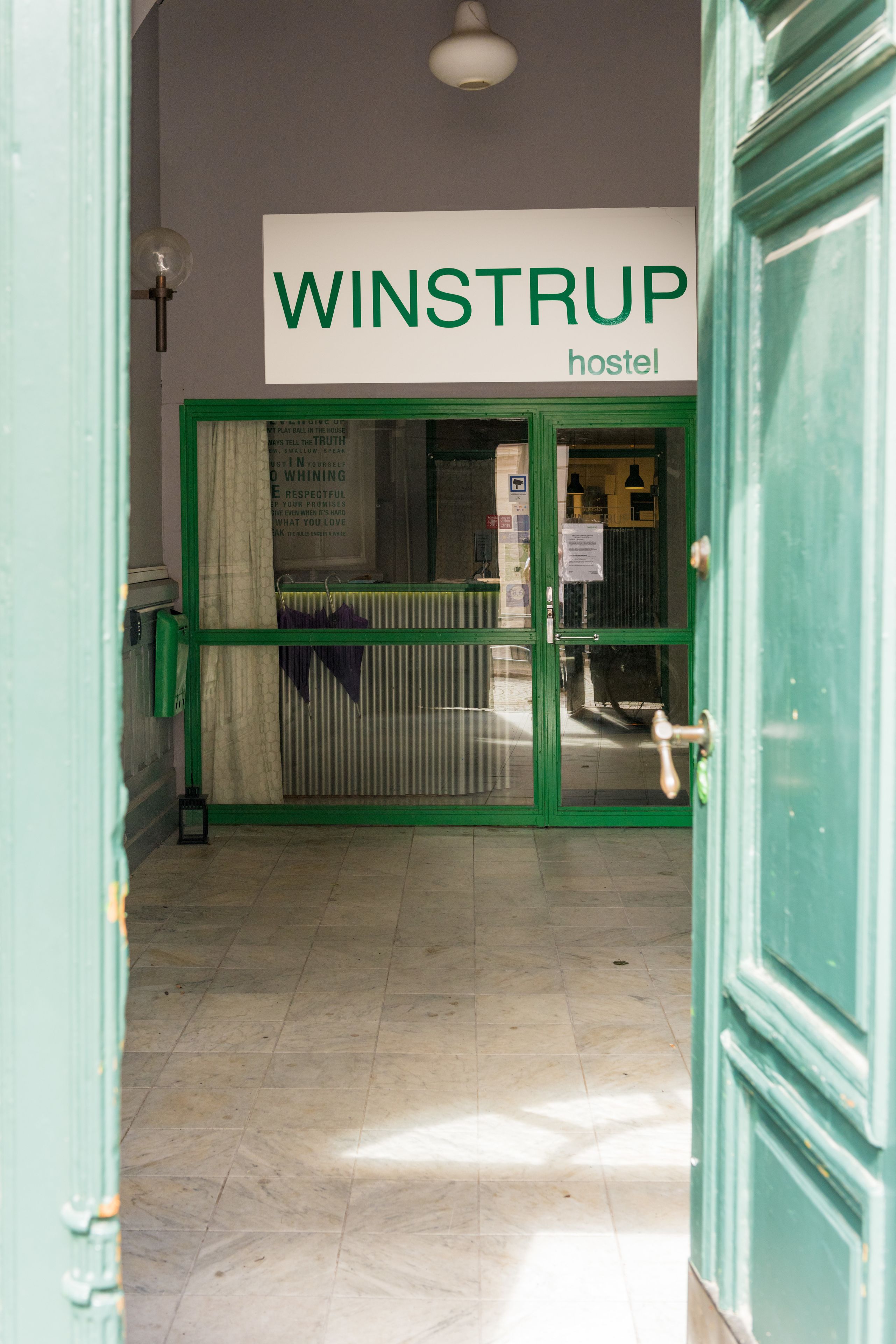 Entrada a un hostal con un letrero que dice 'WINSTRUP hostel'.