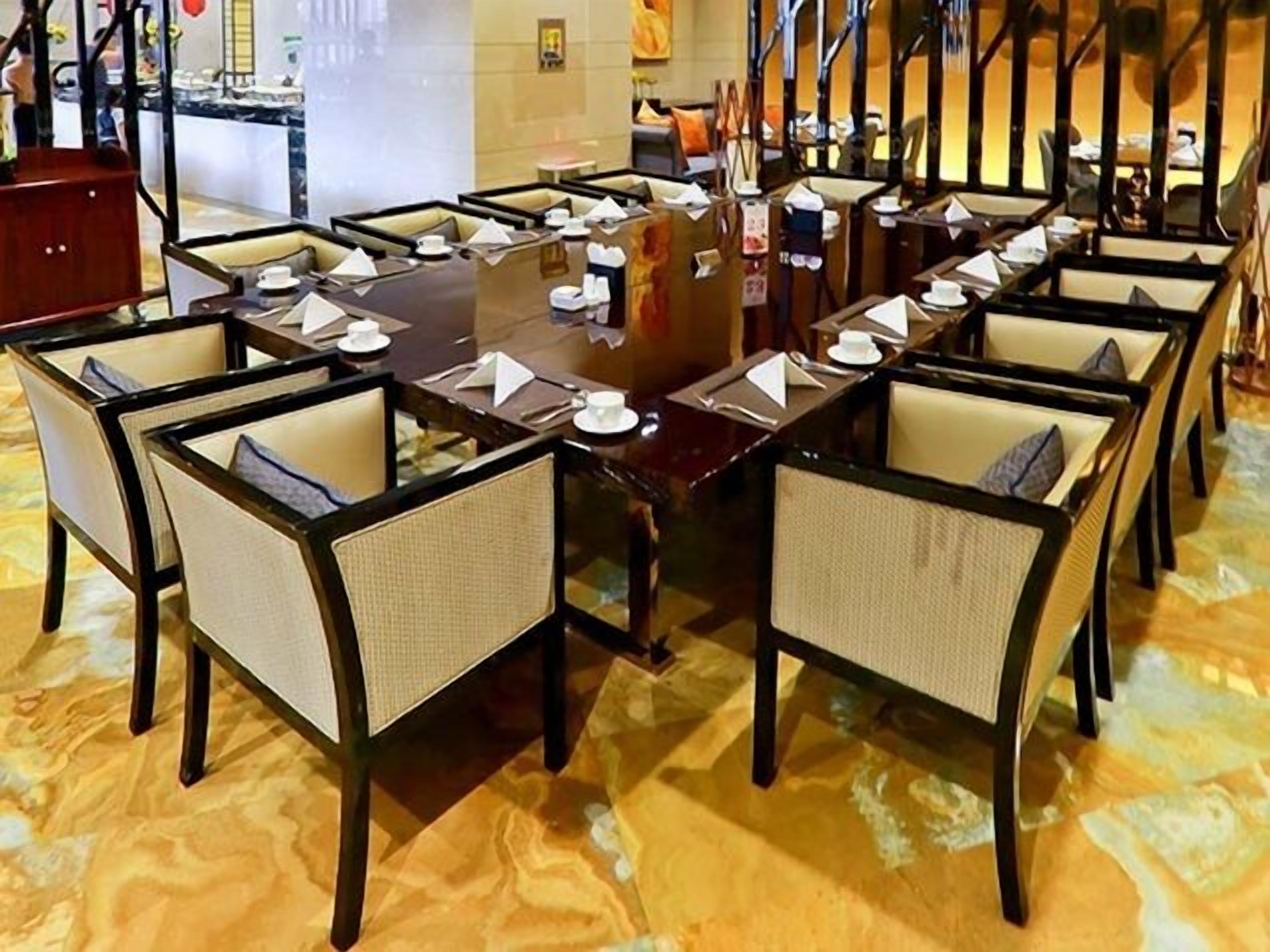 A conference room with a large rectangular table surrounded by chairs with cushioned seats and backs.