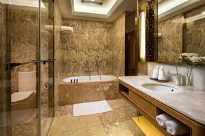 Un baño moderno con ducha de vidrio, una bañera independiente y un tocador con un espejo grande.
