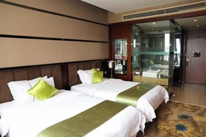 A hotel room with two beds, a large mirror, and a sliding glass door leading to a bathroom. - Liwan International Hotel (Chengdu)