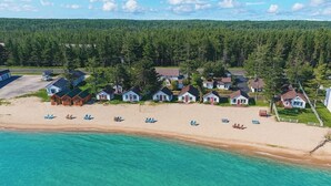 Vista aérea de un complejo turístico costero con varias cabañas y servicios en la playa.
