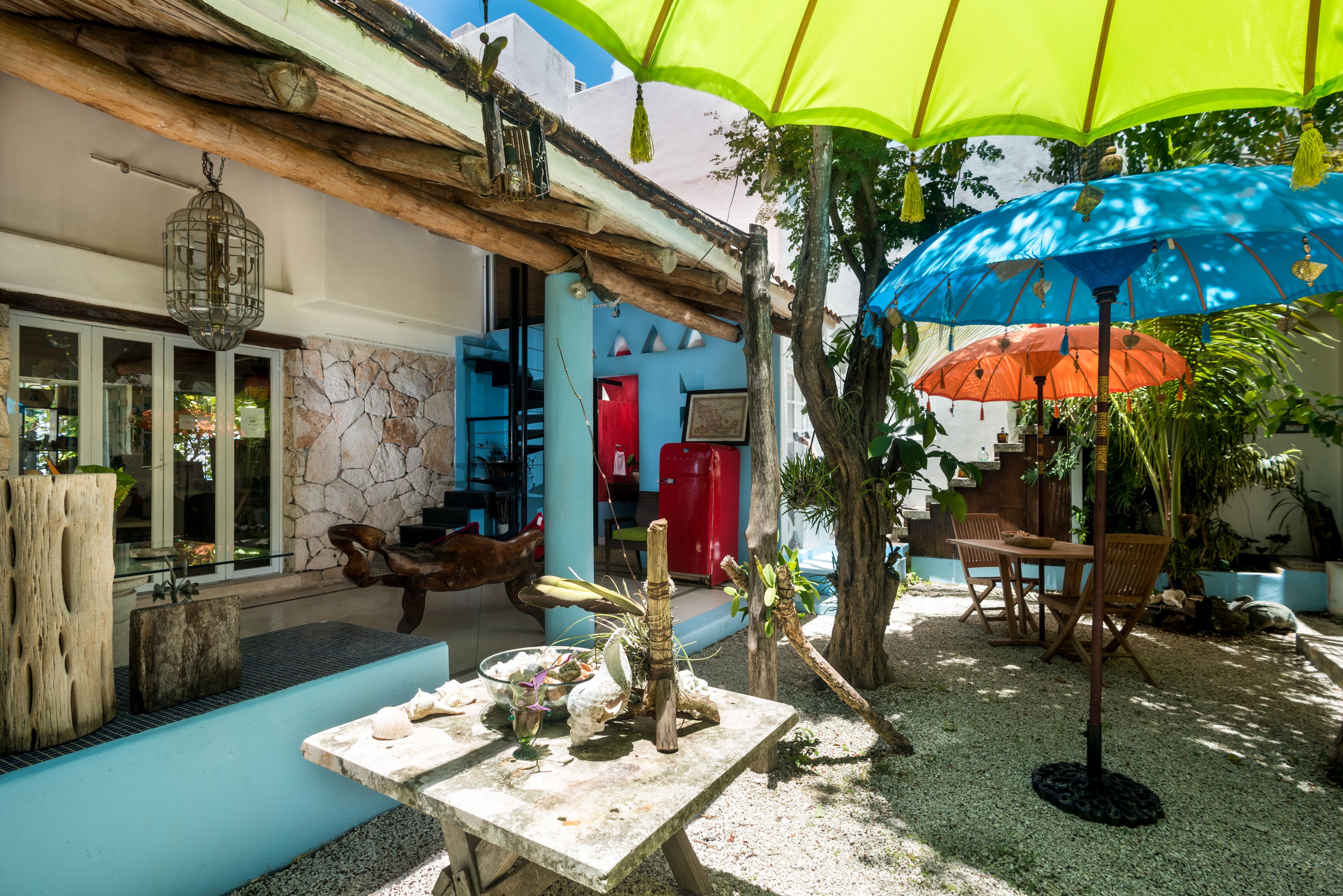 Un espace extérieur aménagé avec une table, des chaises et des parasols.