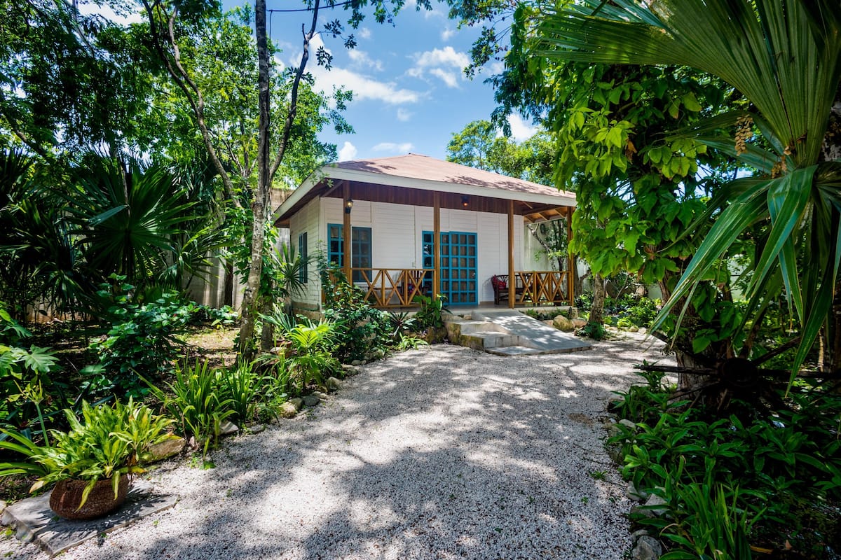 A house with a gravel pathway leading to a wooden porch.