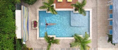 Una piscina al aire libre, sillones reclinables de piscina