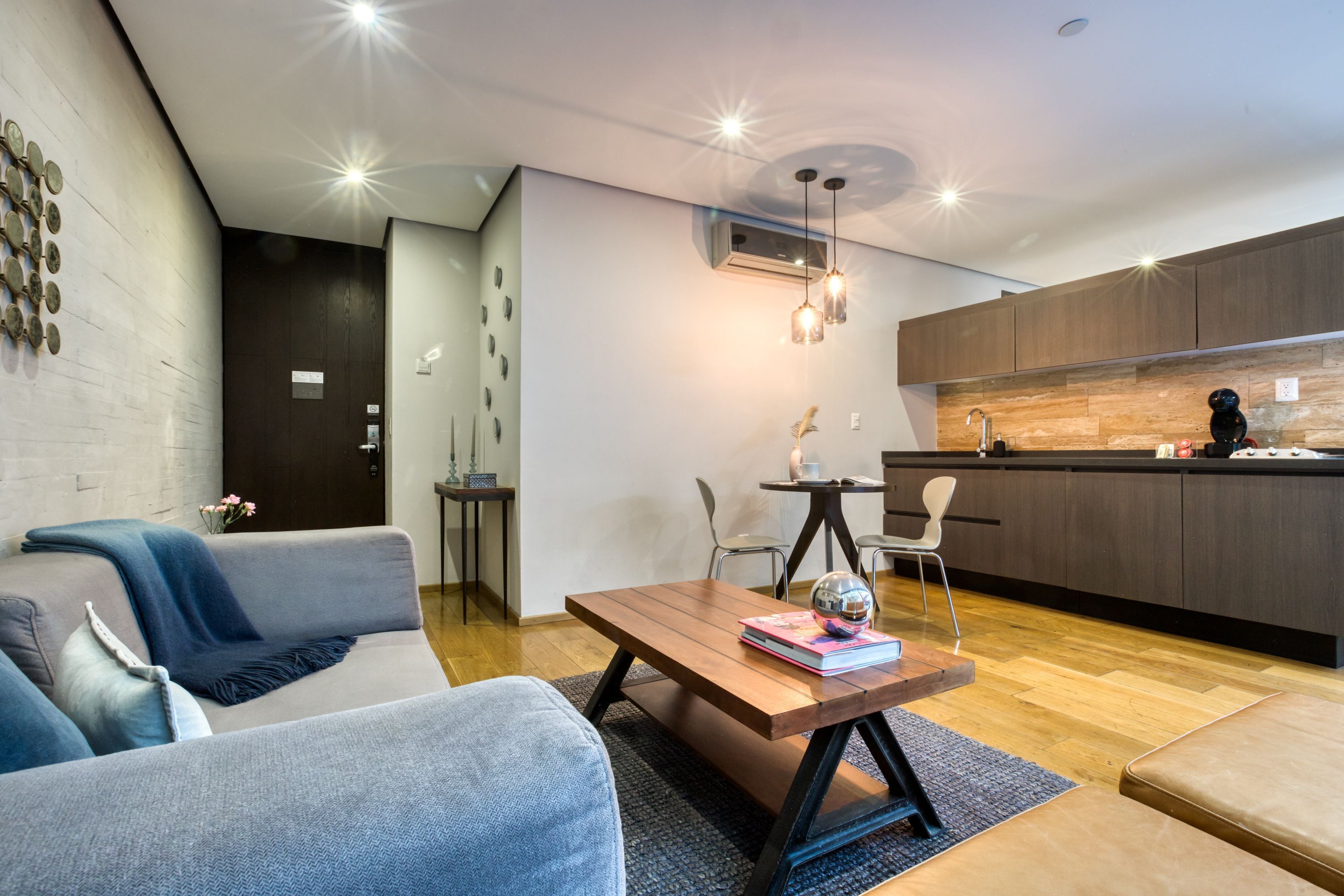 Ein modernes Wohnzimmer mit einer Couch, einem Couchtisch und einem Essbereich mit Stühlen.